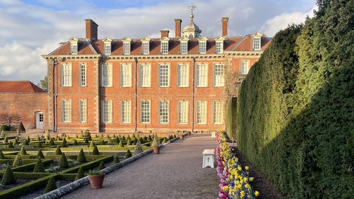 A view of Hanbury Hall from the Parterre garden with the ribbon border filled with daffodils and hyacinths